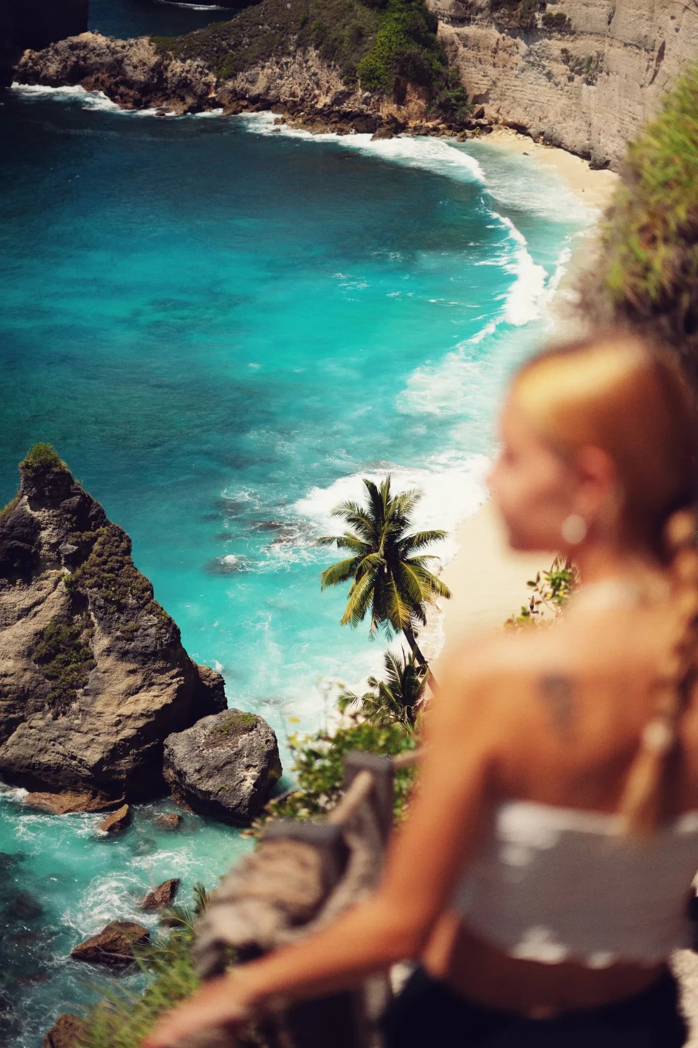 Mujer contemplando acantilados y mar turquesa