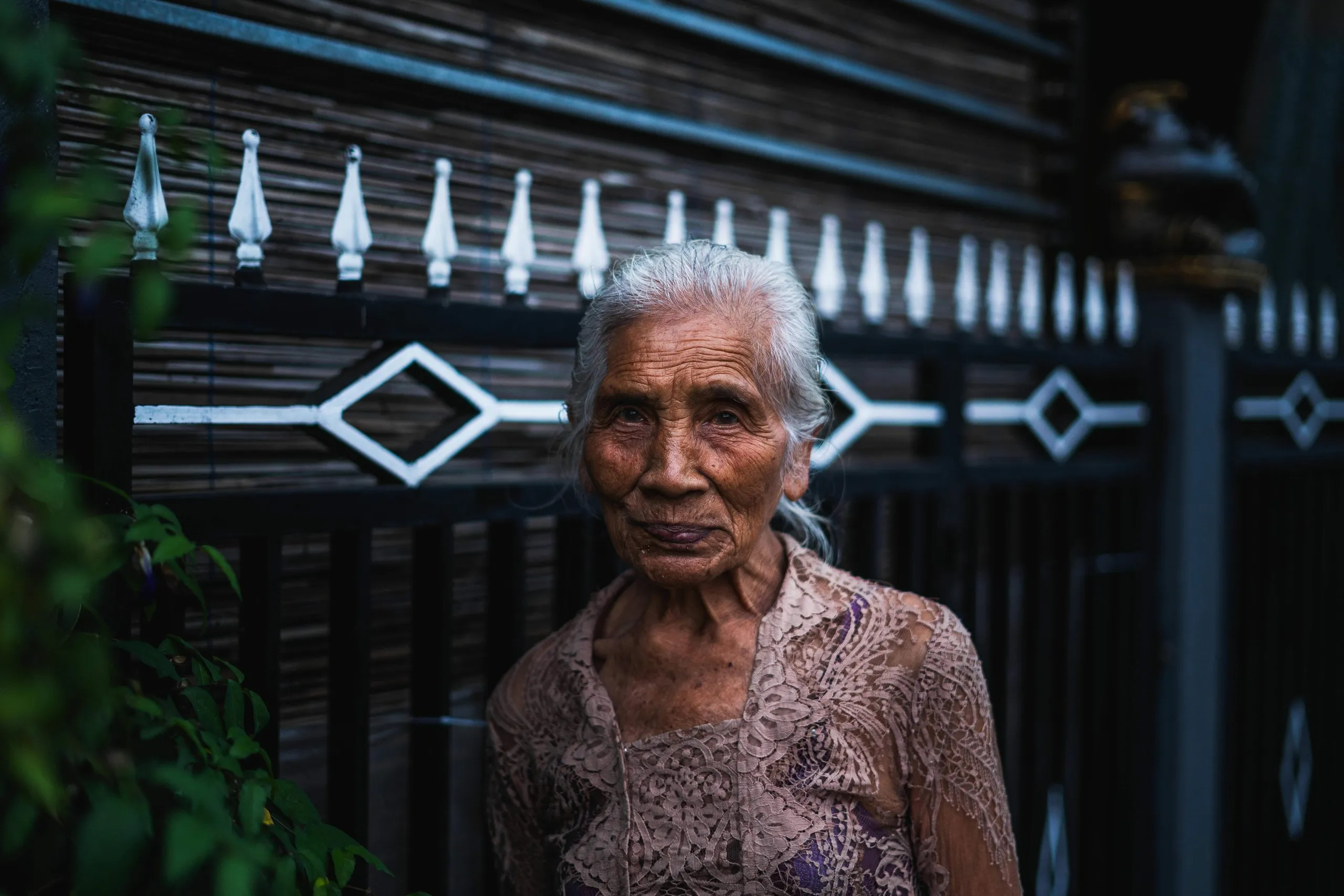 Mujer mayor ante una puerta de madera tallada