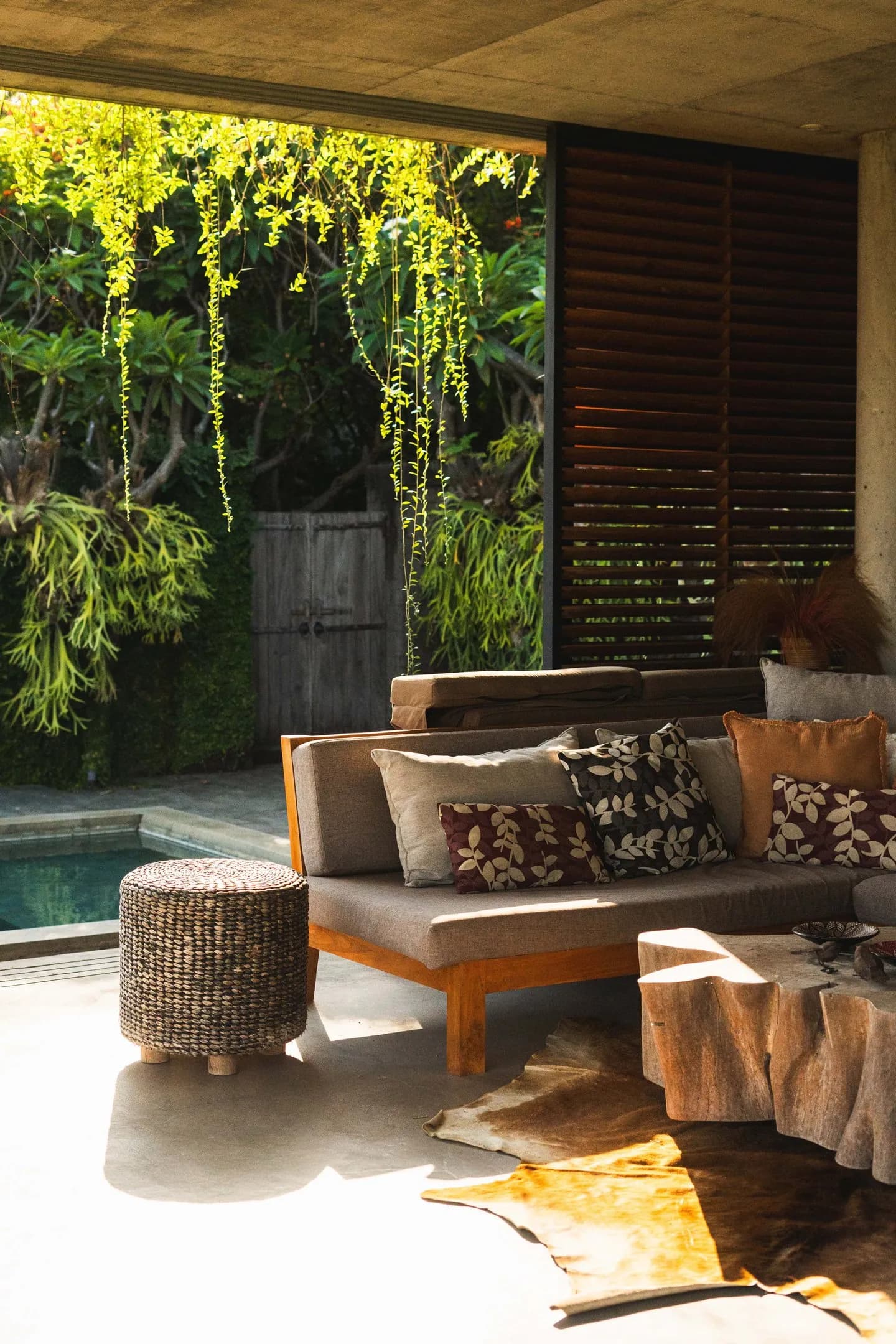 Salón de villa abierto a la selva junto a una piscina
